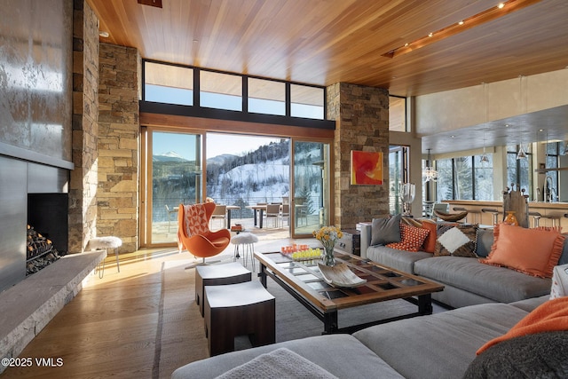 34 Whiskey Rdg, Edwards, CO 81632 - living room featuring a mountain view, a fireplace, wood ceiling, a towering ceiling, and wood finished floors