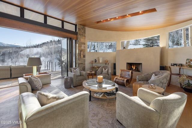 living room featuring a mountain view, a wealth of natural light, wooden ceiling, and wood-type flooring