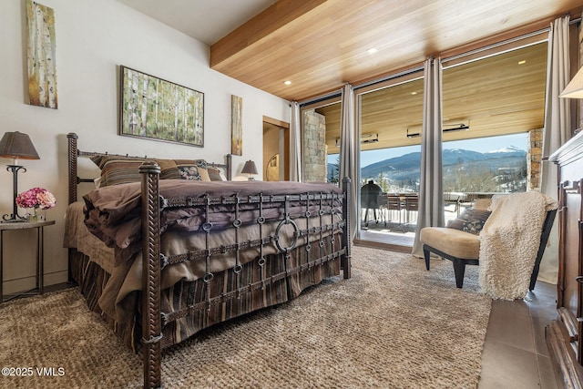 bedroom with a mountain view, wooden ceiling, expansive windows, and access to exterior