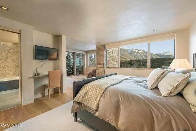 bedroom featuring multiple windows and light hardwood / wood-style flooring