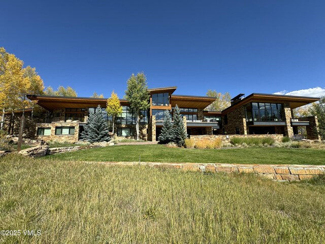 rear view of property featuring a lawn