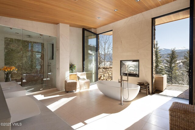 interior space featuring floor to ceiling windows, a mountain view, wooden ceiling, and tile patterned floors