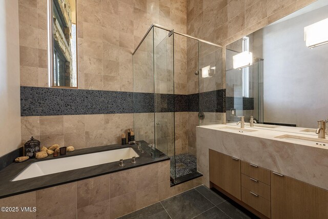 bathroom featuring vanity, plus walk in shower, tile patterned flooring, and tile walls