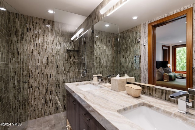 bathroom with double vanity, a sink, tile walls, and a walk in shower