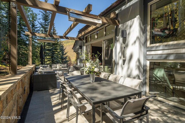 view of patio featuring outdoor dining area, an outdoor living space, and a pergola