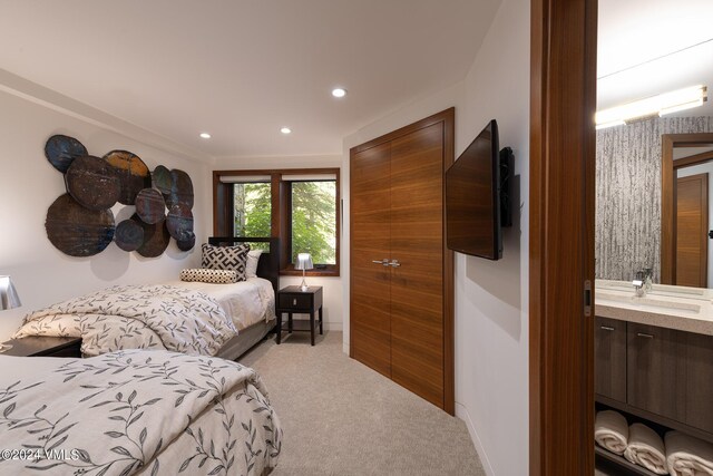 carpeted bedroom with recessed lighting, a sink, and baseboards