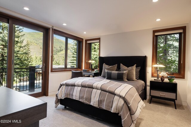 bedroom with light carpet, access to outside, multiple windows, and recessed lighting