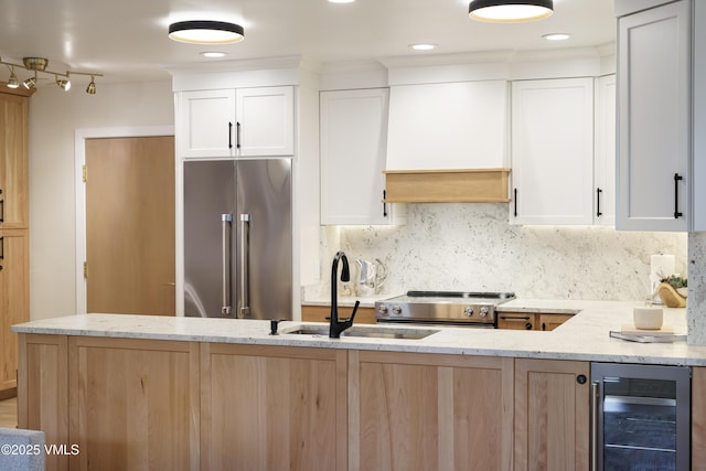 180 Offerson Rd Unit 2, Beaver Creek, CO 81620 - kitchen with appliances with stainless steel finishes, beverage cooler, light stone counters, a sink, and tasteful backsplash
