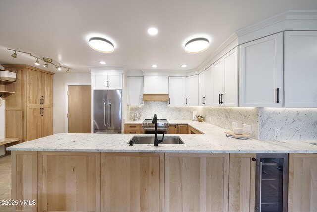180 Offerson Rd Unit 2, Beaver Creek, CO 81620 - kitchen featuring premium appliances, wine cooler, a peninsula, and light stone counters