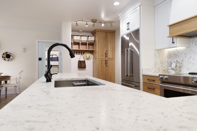 180 Offerson Rd Unit 2, Beaver Creek, CO 81620 - kitchen with stainless steel appliances, a sink, premium range hood, light stone countertops, and decorative backsplash