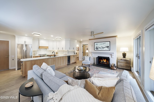 180 Offerson Rd Unit 2, Beaver Creek, CO 81620 - living area featuring wine cooler, a glass covered fireplace, light wood finished floors, a ceiling fan, and recessed lighting