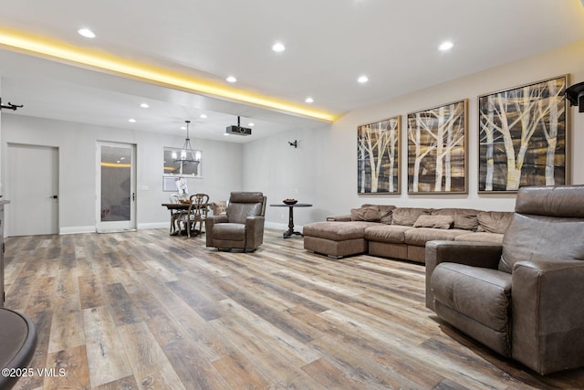 living area featuring baseboards, beamed ceiling, wood finished floors, and recessed lighting