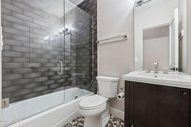 full bath featuring toilet, shower / bath combination with glass door, baseboards, and vanity