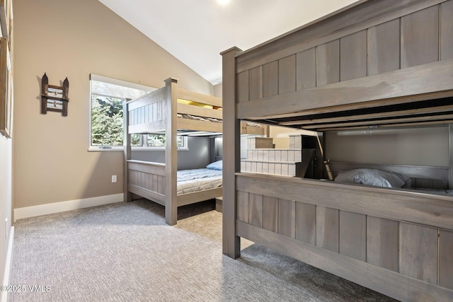 carpeted bedroom with vaulted ceiling and baseboards