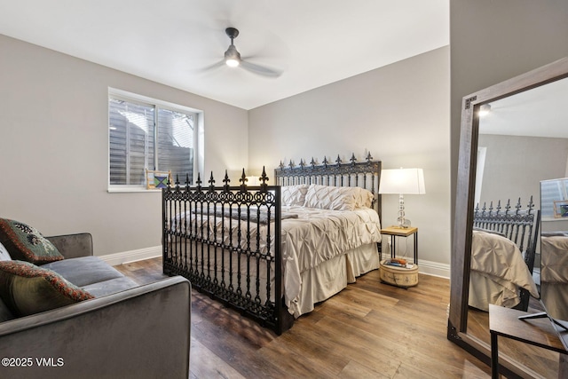 bedroom with ceiling fan, baseboards, and wood finished floors