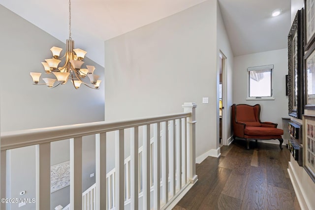 corridor with baseboards, vaulted ceiling, dark wood-style flooring, and a chandelier