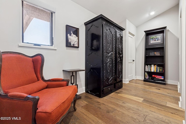 sitting room with lofted ceiling, recessed lighting, baseboards, and wood finished floors