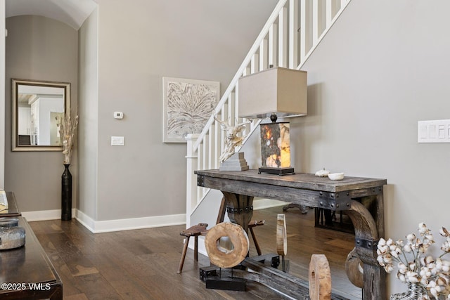 office featuring wood finished floors, a towering ceiling, and baseboards