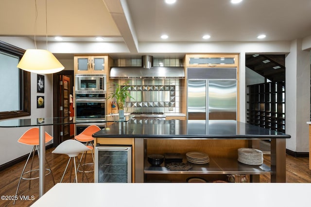 266 Sawatch Dr, Edwards, CO 81632 - kitchen with built in appliances, wall chimney exhaust hood, dark wood-style floors, dark countertops, and recessed lighting