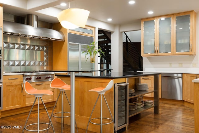 266 Sawatch Dr, Edwards, CO 81632 - kitchen with appliances with stainless steel finishes, wall chimney exhaust hood, wine cooler, a breakfast bar area, and dark wood-style flooring