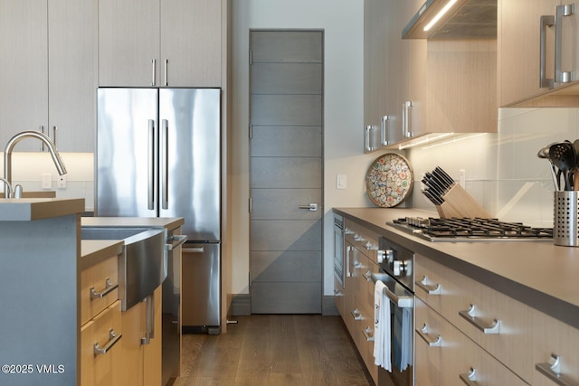37347 US Highway 6 Unit 101, Avon, CO 81620 - kitchen with appliances with stainless steel finishes, dark wood finished floors, extractor fan, and light brown cabinets