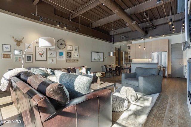 37347 US Highway 6 Unit 101, Avon, CO 81620 - living room with track lighting, a high ceiling, and wood finished floors