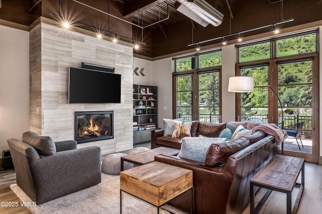 37347 US Highway 6 Unit 101, Avon, CO 81620 - living area with wood finished floors, a high end fireplace, track lighting, and a towering ceiling