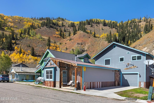 216 Monument St, Red Cliff, CO 81649 - view of front of home featuring an attached garage, concrete driveway, and a mountain view
