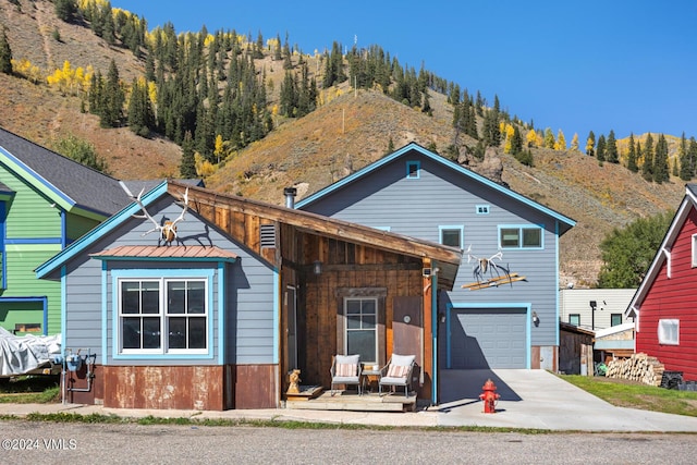 216 Monument St, Red Cliff, CO 81649 - view of front facade with driveway, a mountain view, and an attached garage