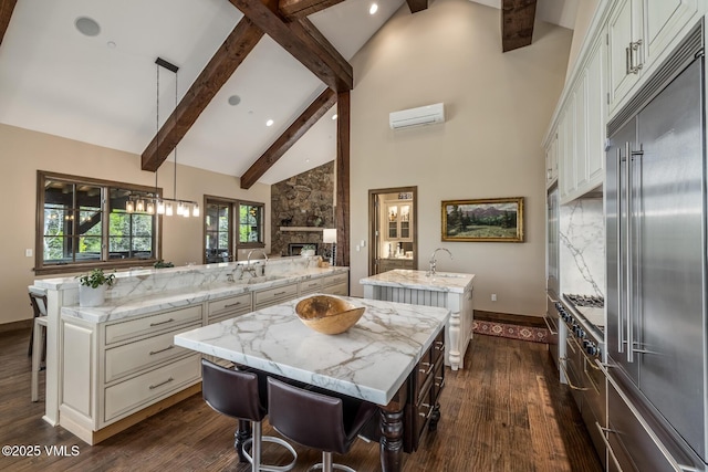 348 Red Draw, Edwards, CO 81632 - kitchen with a large island, built in fridge, high vaulted ceiling, a wall mounted air conditioner, and dark wood-style floors