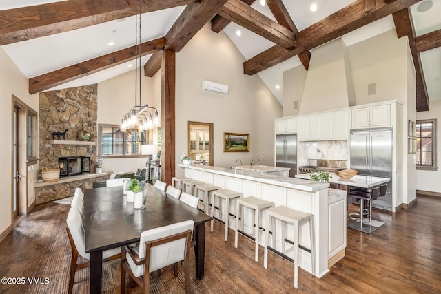 348 Red Draw, Edwards, CO 81632 - dining space with high vaulted ceiling, beam ceiling, a stone fireplace, dark wood finished floors, and baseboards