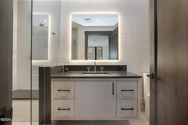 bathroom featuring vanity, tile patterned flooring, and tile walls