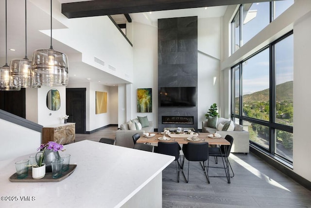 42 Riverfront Ln Unit 507, Avon, CO 81620 - dining room with plenty of natural light, a high ceiling, wood finished floors, and a large fireplace