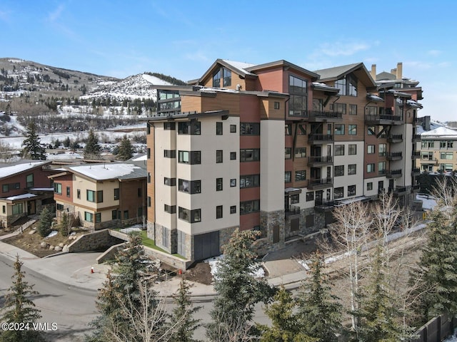 snow covered building featuring a mountain view