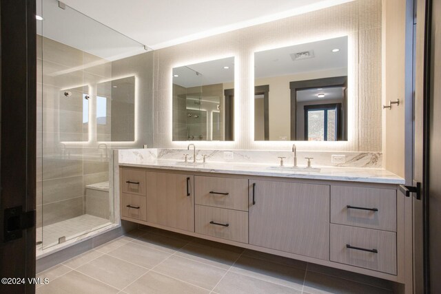 bathroom with vanity, tile patterned floors, backsplash, and a shower with shower door