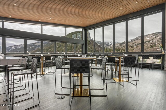 sunroom with a mountain view and wooden ceiling