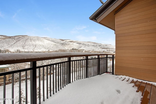 snow covered back of property featuring a mountain view