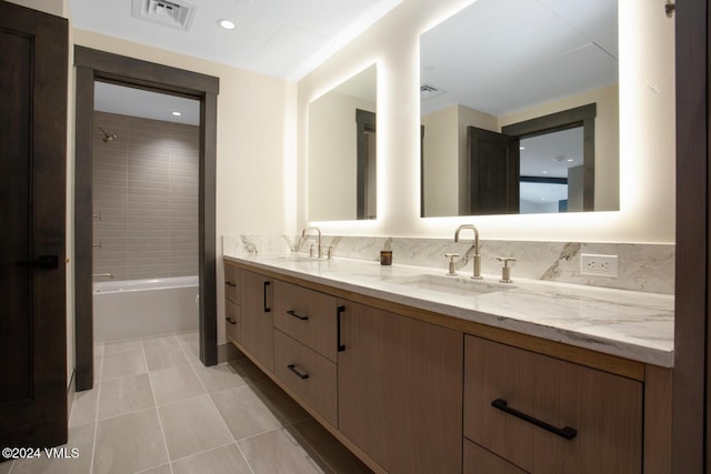 bathroom with tasteful backsplash, tiled shower / bath, vanity, and tile patterned flooring