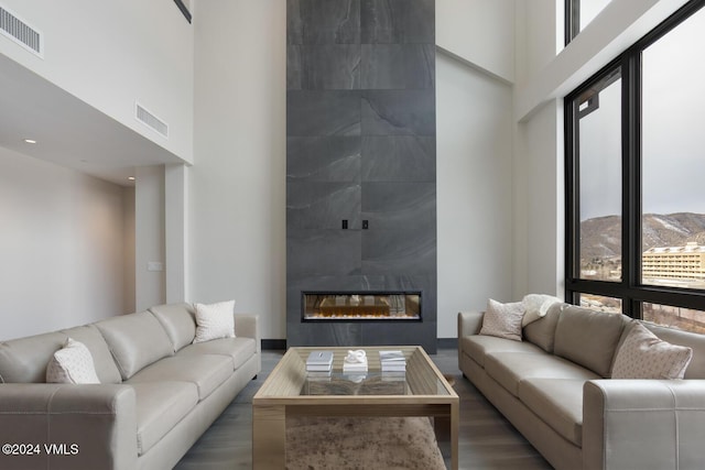 living room featuring a mountain view, a fireplace, and a high ceiling