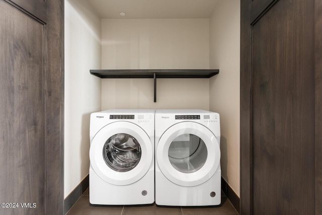 laundry area with washing machine and clothes dryer and dark tile patterned flooring