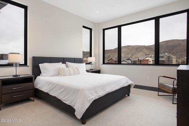 bedroom with a mountain view and light carpet