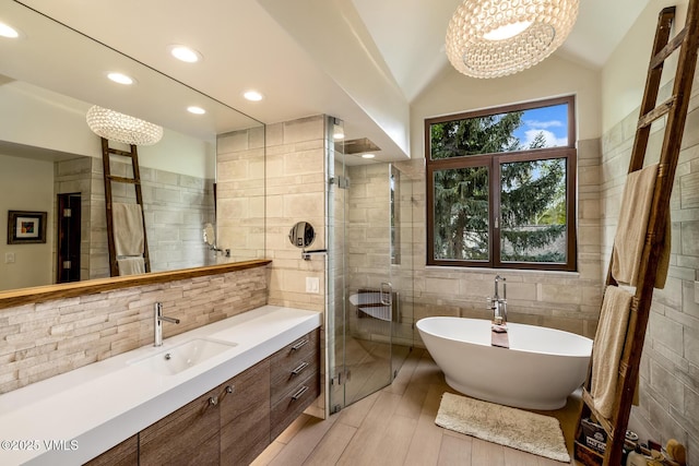 89 Trout Pond Ln, Avon, CO 81620 - bathroom with tile walls, vanity, a soaking tub, a chandelier, and lofted ceiling