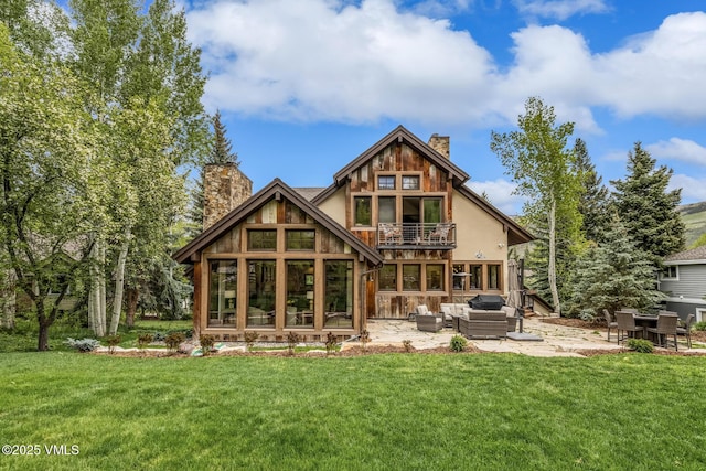 89 Trout Pond Ln, Avon, CO 81620 - rear view of house with a balcony, a chimney, a patio, an outdoor living space, and a lawn