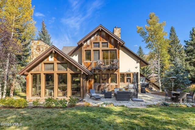 89 Trout Pond Ln, Avon, CO 81620 - back of house featuring a chimney, a patio, a balcony, and a lawn