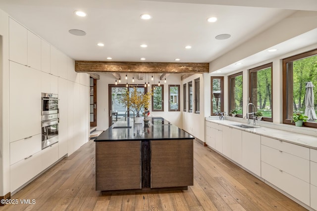 89 Trout Pond Ln, Avon, CO 81620 - kitchen with modern cabinets, recessed lighting, white cabinets, a center island with sink, and beam ceiling