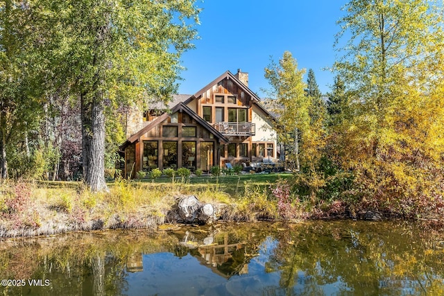 89 Trout Pond Ln, Avon, CO 81620 - rear view of house with a chimney, a balcony, and a water view