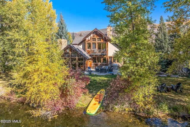 89 Trout Pond Ln, Avon, CO 81620 - back of house with a chimney, a balcony, a patio area, and an outdoor hangout area