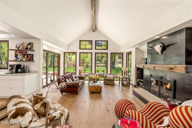 89 Trout Pond Ln, Avon, CO 81620 - living room with beamed ceiling, high vaulted ceiling, a glass covered fireplace, and light wood-style floors