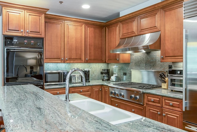 62 Highlands Ln Unit R103, R102, Beaver Creek, CO 81620 - kitchen featuring exhaust hood, stainless steel appliances, brown cabinetry, and decorative backsplash
