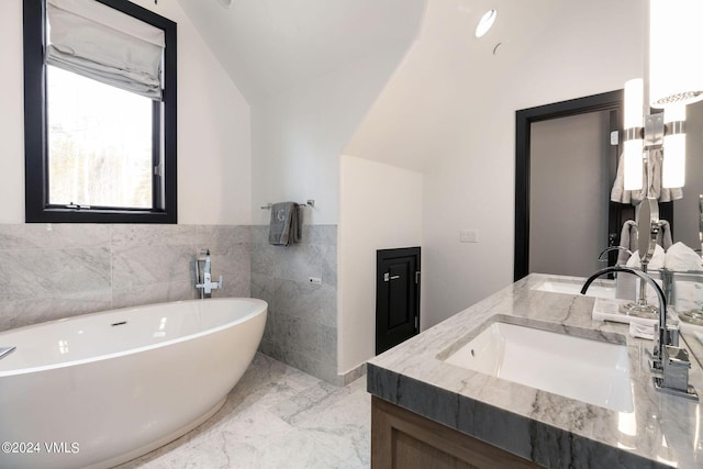 bathroom with vanity, lofted ceiling, and a washtub